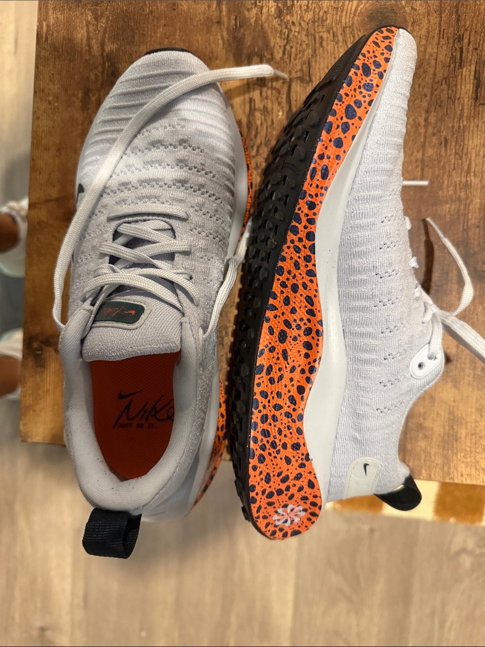 Nike Women’s  White and Orange Speckled Sole Flyknit Sneakers